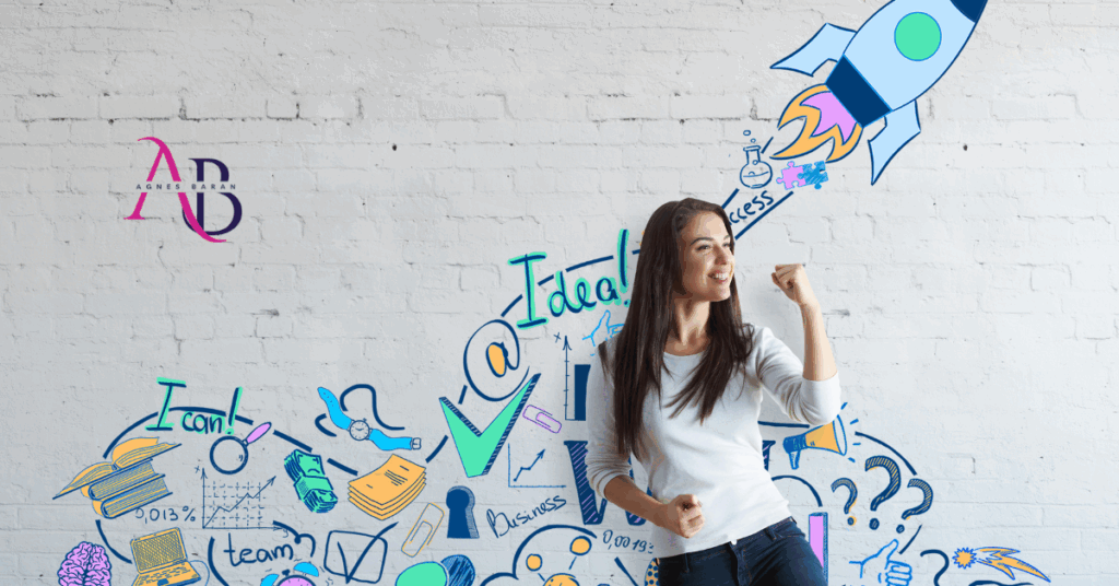 Uśmiechnięta kobieta z uniesioną pięścią na tle kolorowych rysunków symbolizujących rozwój i start biznesu.
