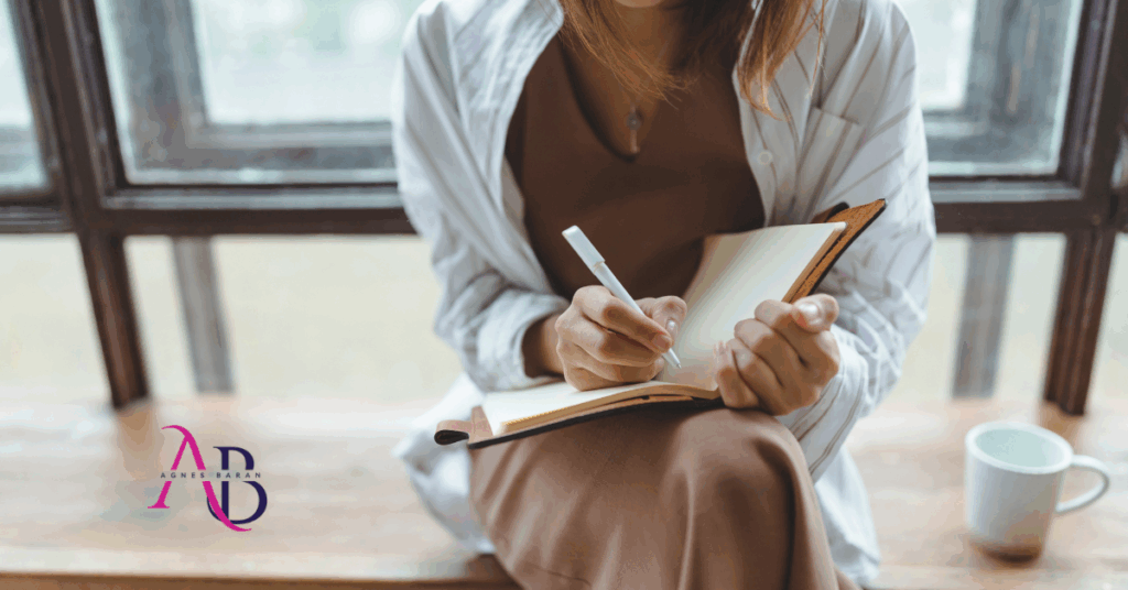 Kobieta zapisująca notatki w dzienniku, symbolizująca odkrywanie zawodowej tożsamości